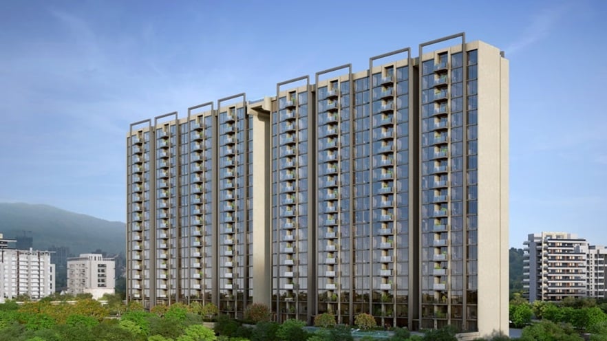 The building is surrounded by trees. It has curtain walls and balconies on the facade.