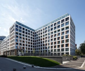 Modern residential building Park 11 with large aluminum windows, balconies, and a light-colored façade featuring clean, geometric lines