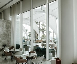The indoor sitting area in earth tones, overlooking the outdoor through large windows