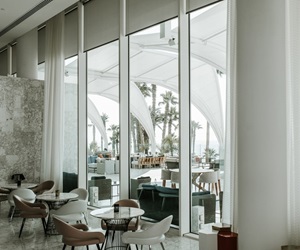The indoor sitting area in earth tones, overlooking the outdoor through large windows