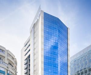 The building has a glass façade and a side with cladding and balconies