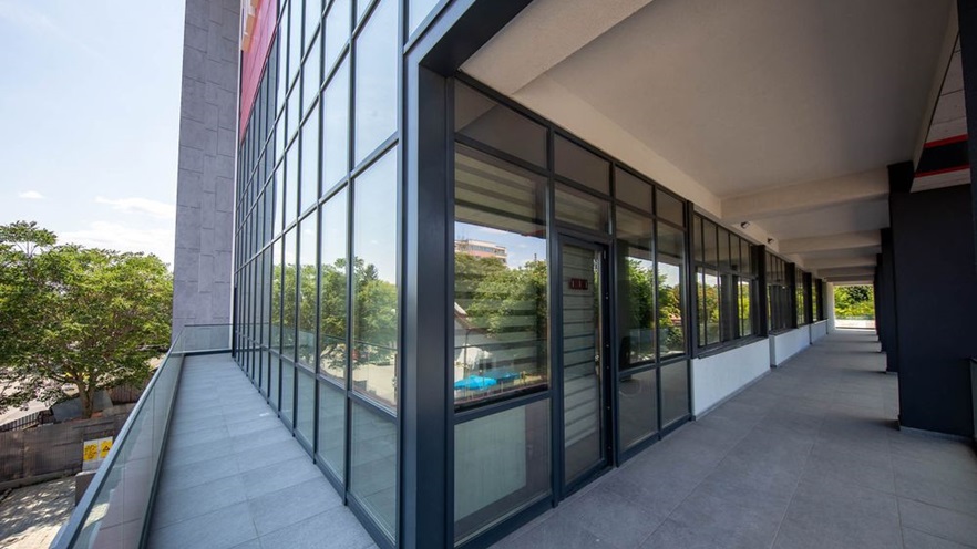 The balcony level has a curtain wall with door and window openings