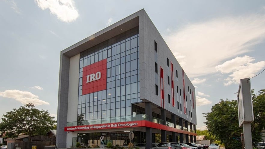 The building has a large curtain wall façade at the front with a large red sign