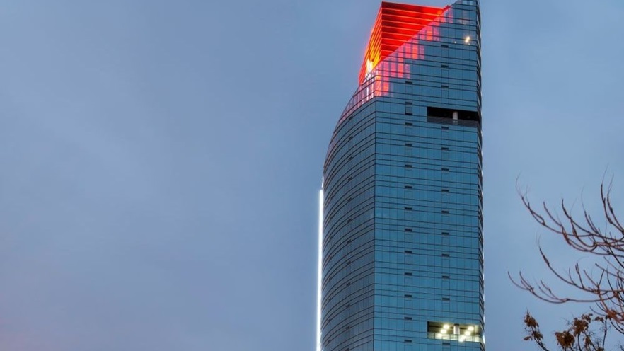 the glass tower has a red section coming through the angled top