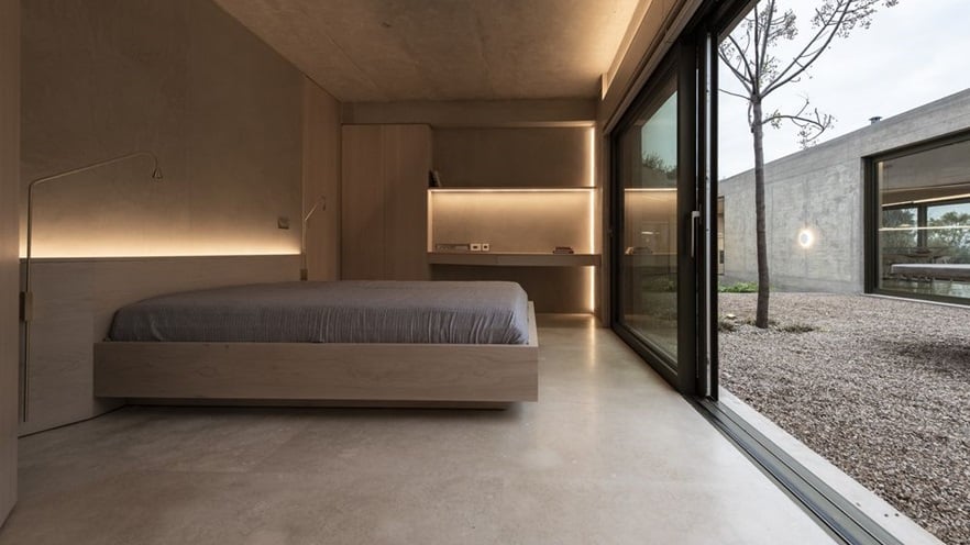 The bedroom area has a bed and a desk and a large window overlooking the courtyard