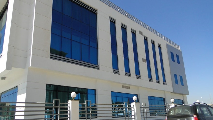 Building with glass façades and windows seen from outside the fence