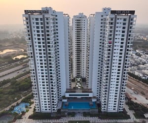 The three towers are white and provide many balconies and windows