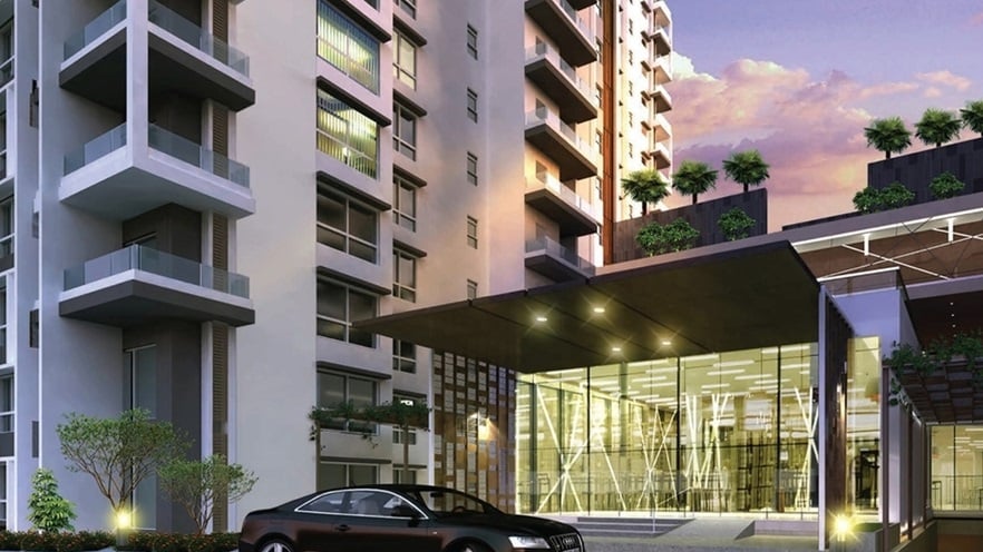 A luxury car is parked in front of the building entrance that is made of glass and has special constructions for lighting