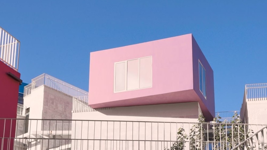 A pink square room randomly placed on the white building