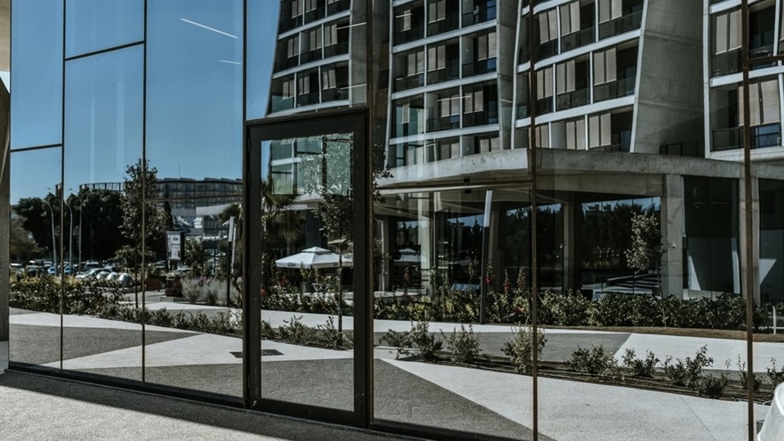 Glass façade with fire exit that reflects the building across the street