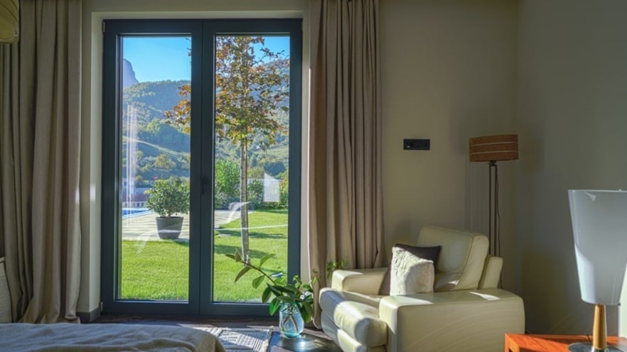 The bright bedroom has a cozy armchair by the window