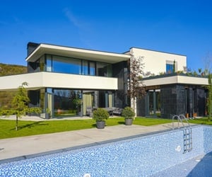 Modern villa with a private pool, large sliding aluminum doors, and a spacious terrace area