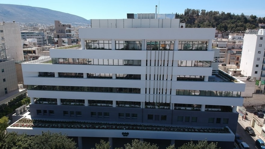 The building has lots of windows and plants on each level