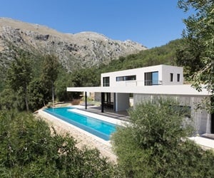 The two-storey building with the pool is located between trees