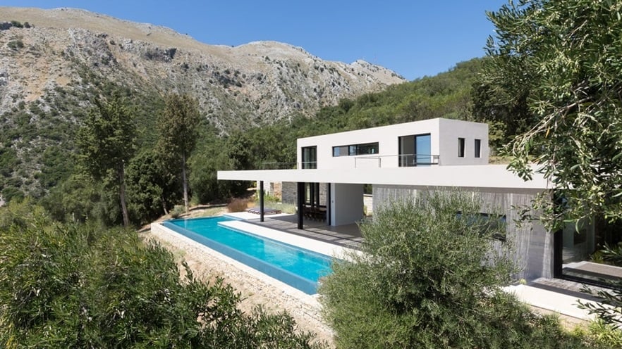 The two-storey building with the pool is located between trees