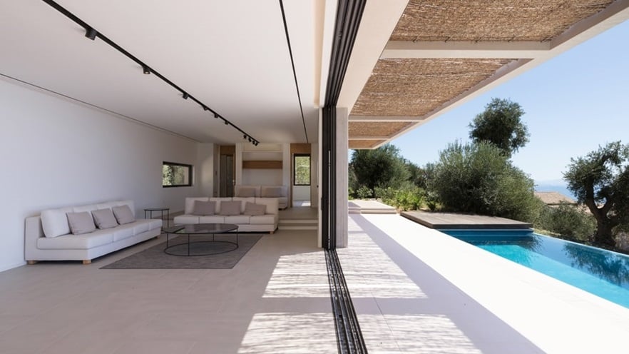 The minimal living room becomes one with the outside when the windows open