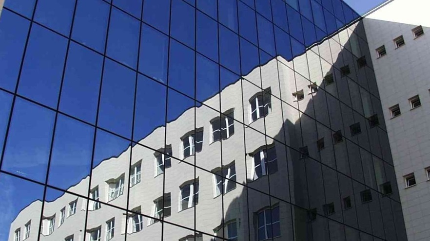 Close up to the curtain wall that reflects the side of the building