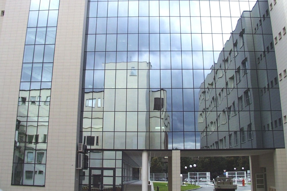 The curtain wall reflects the surrounding buildings