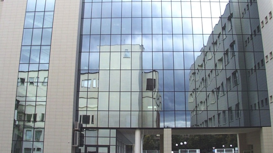 The curtain wall reflects the surrounding buildings