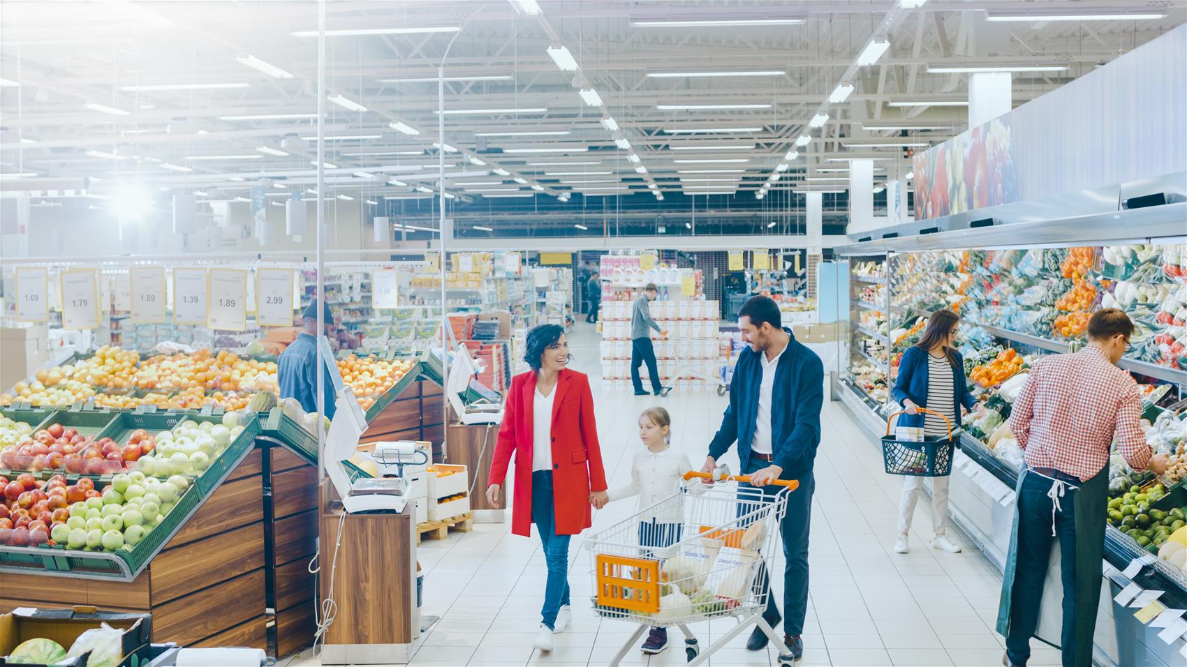 People in Supermarket Supermarket aisle with people walking with shopping carts